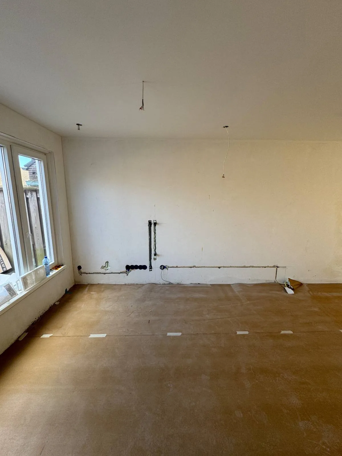 Nieuw leidingwerk langs de wand in een woning in Flevoland