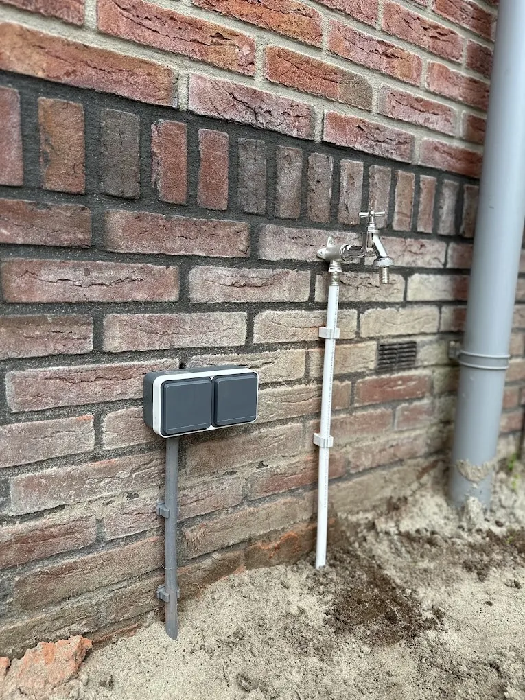Dubbel stopcontact en buitenkraan aan de gevel
